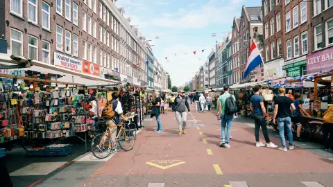 Stalls and shoppers along Albert Cuypstraat in Amsterdam during the day