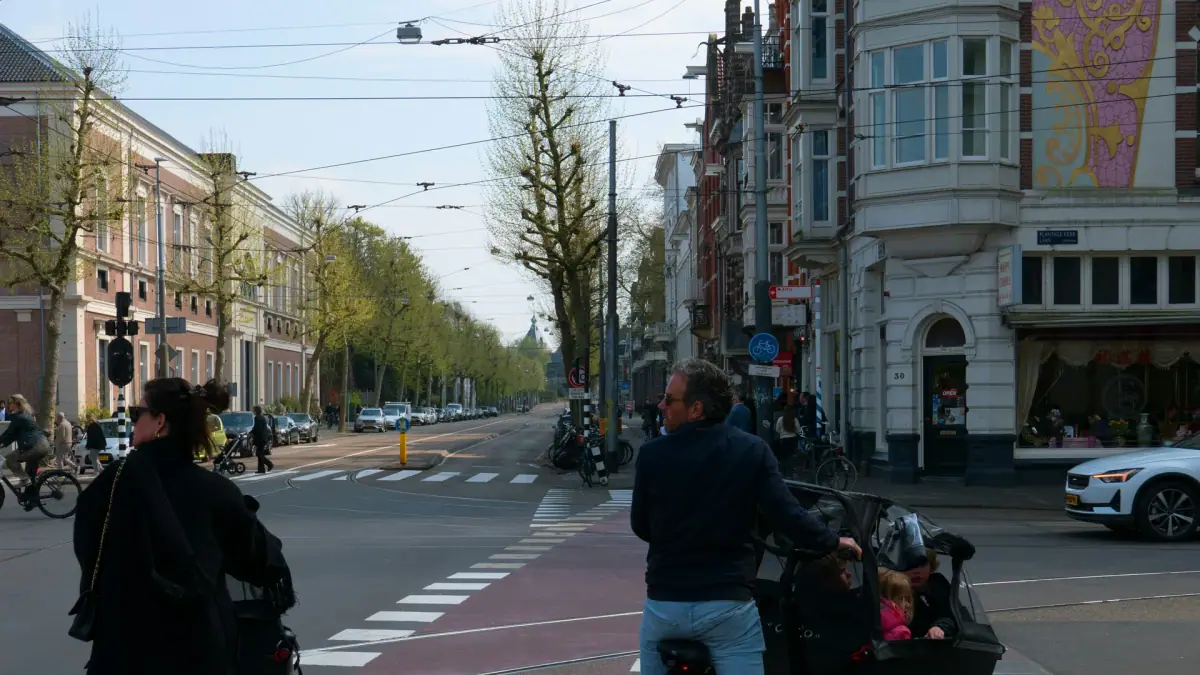 Parents cycling with children in cargo bikes on an Amsterdam street