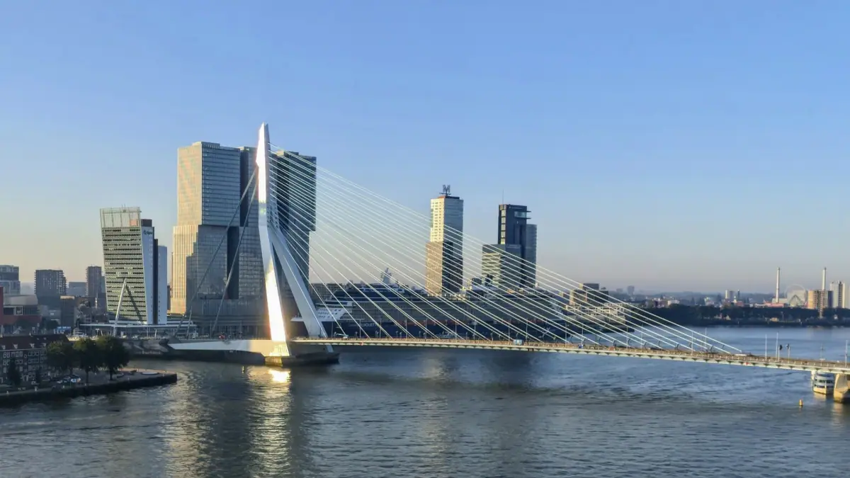 The Erasmusbrug spanning the Nieuwe Maas beside Rotterdam waterfront buildings