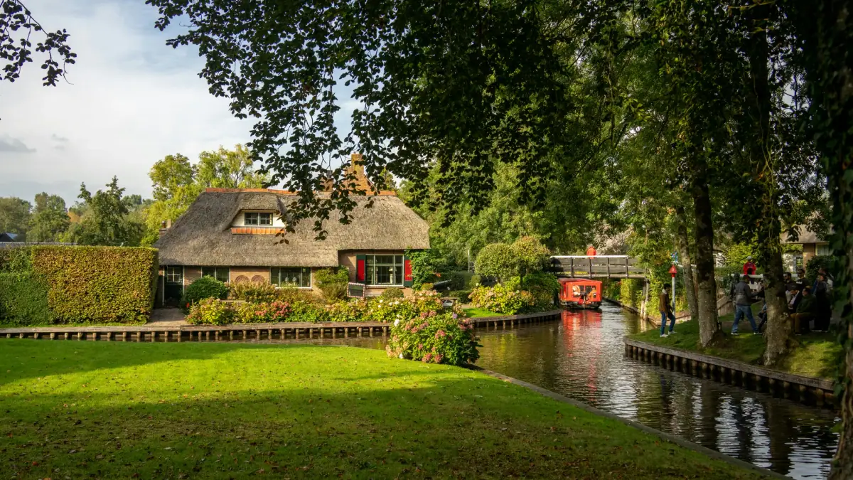 Rietgedekte huizen en houten bruggen langs een kanaal in Giethoorn