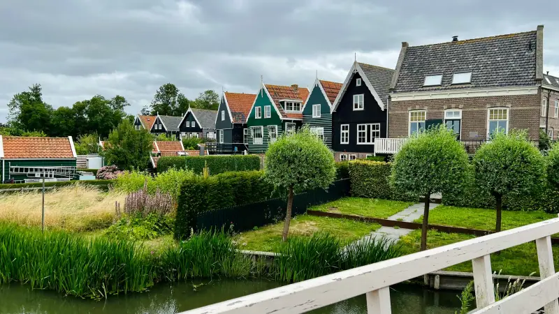 Wooden houses and a white footbridge beside a canal in Marken