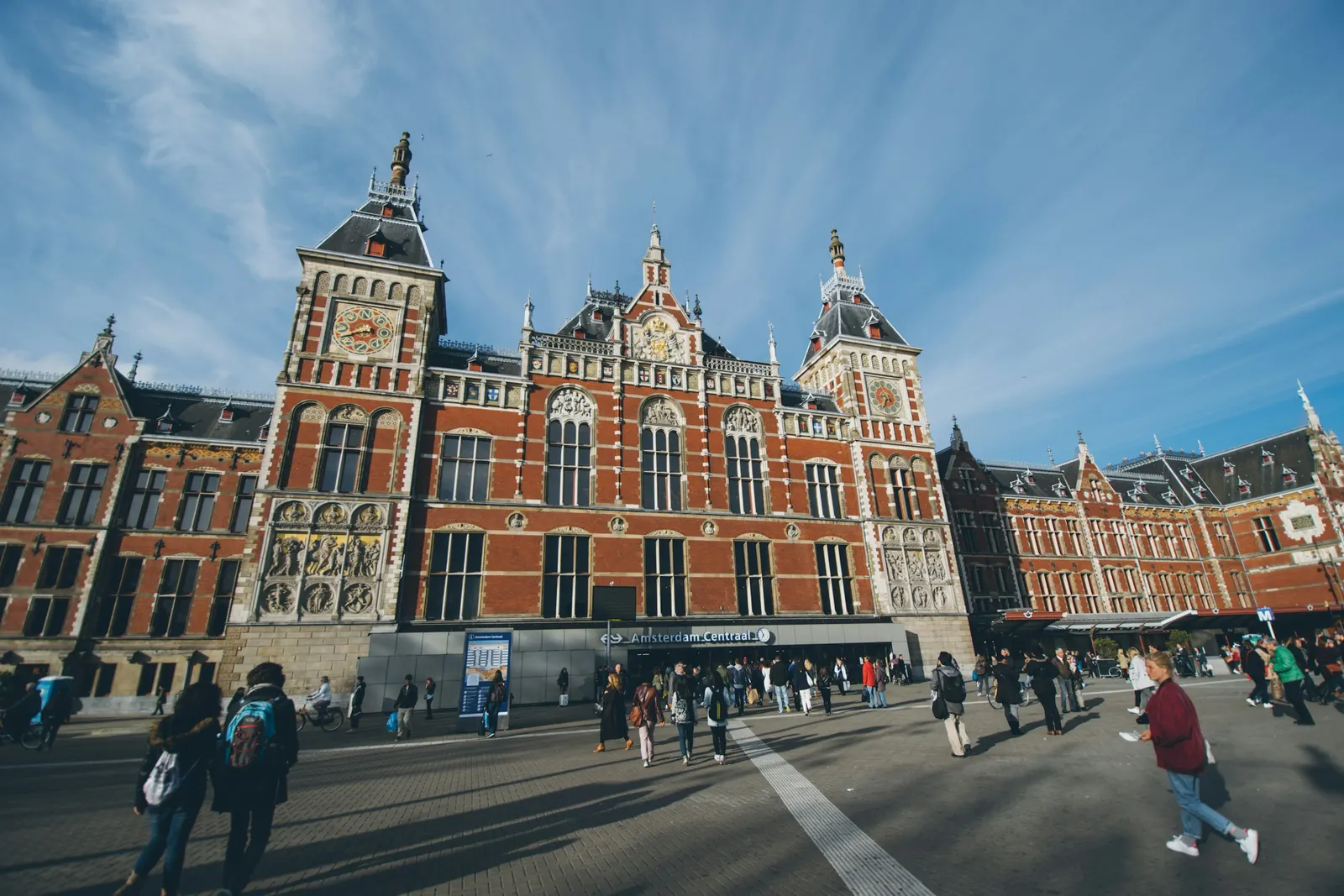 The red-brick facade of Amsterdam Centraal station on a sunny day