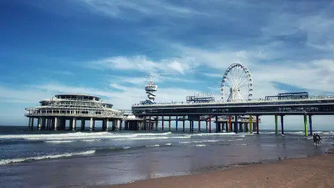 De Scheveningse Pier met het reuzenrad boven de Noordzee bij daglicht