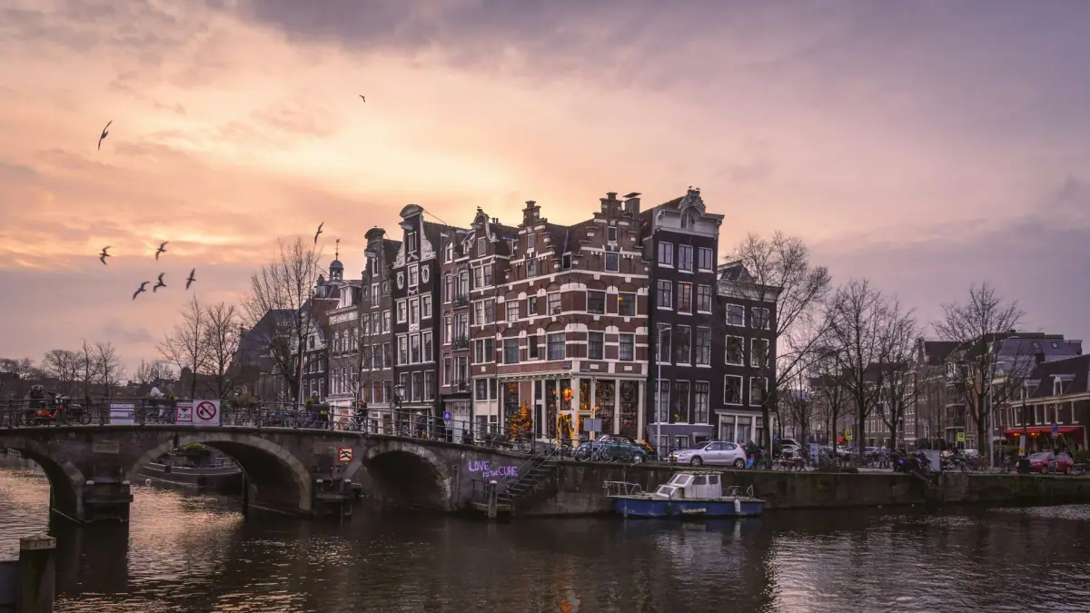 Grachtenpanden en woonboten langs een rustige Amsterdamse gracht